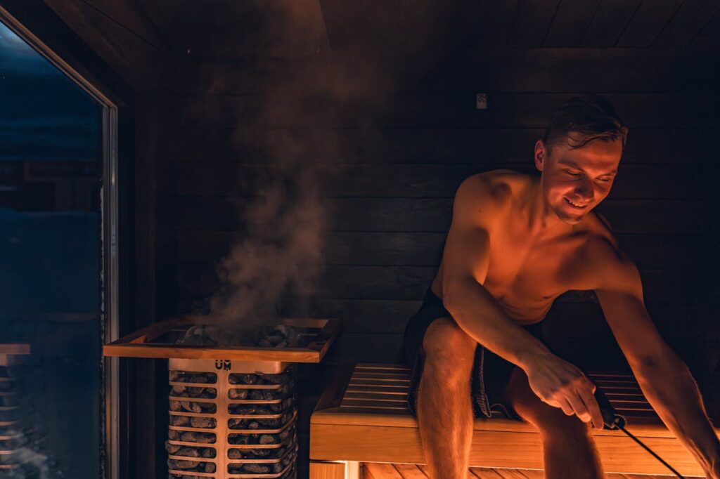 A man enjoying a warm and relaxing sauna session, embracing Nordic design.