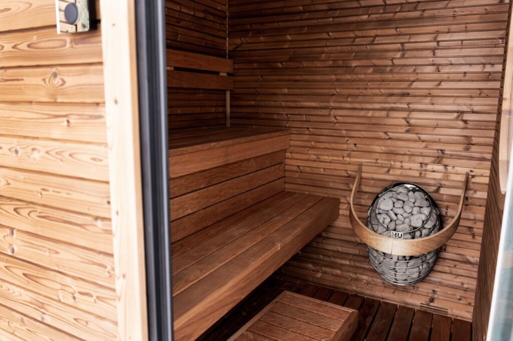 Explore a serene wooden sauna featuring Nordic design and modern electric heater for ultimate relaxation.